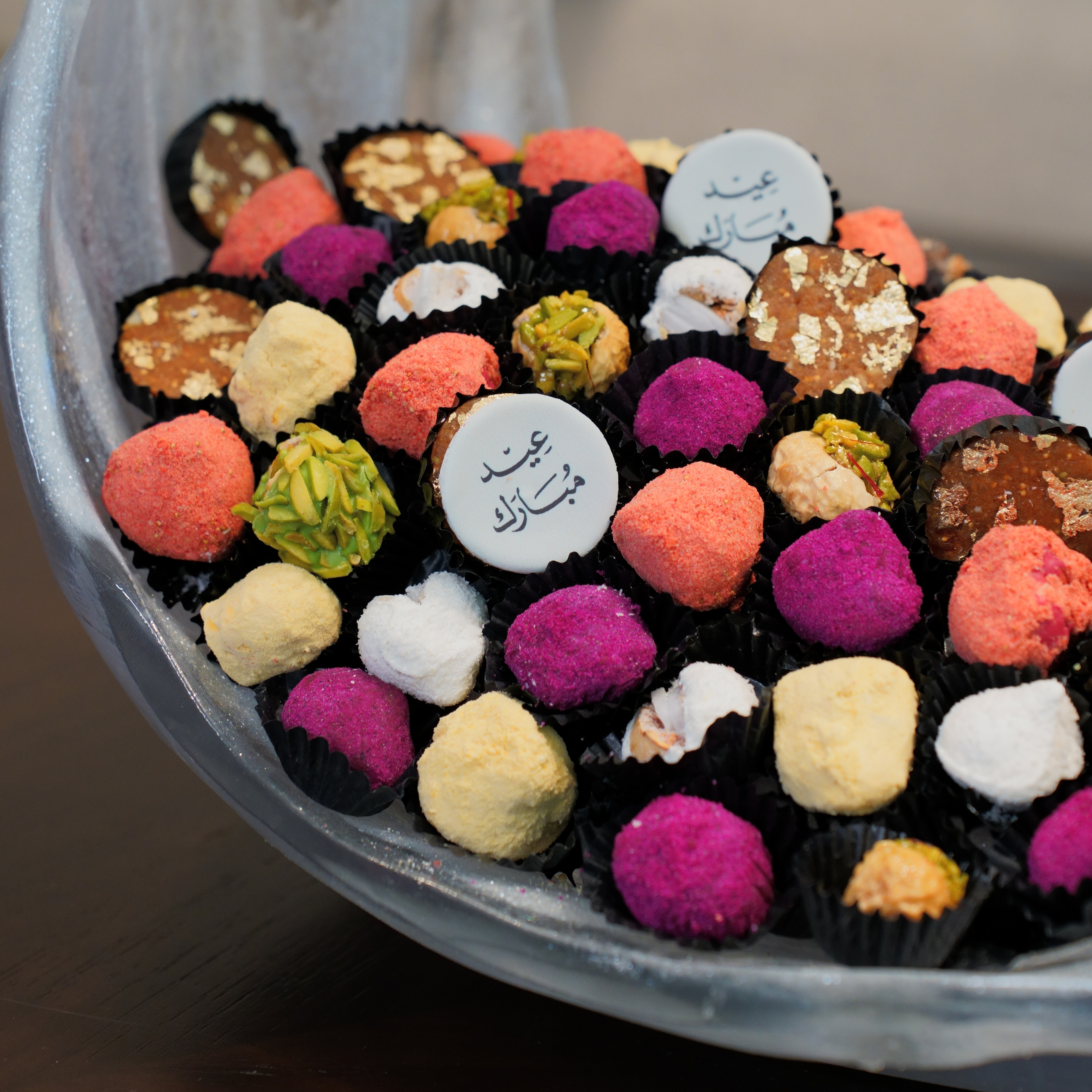 Assorted colorful candies in a metal bowl with 'FIGUR' branding.